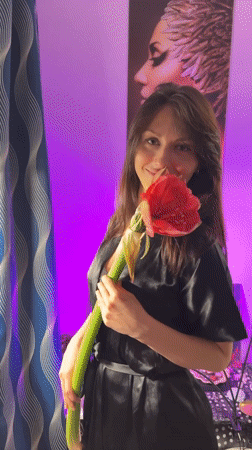 Woman poses with red flowers in Murino apartment photoshoot