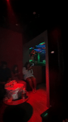 Three people gather at nightclub table in Abuja