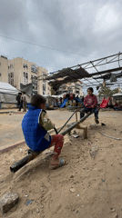 Children play on seesaw in Gaza playground