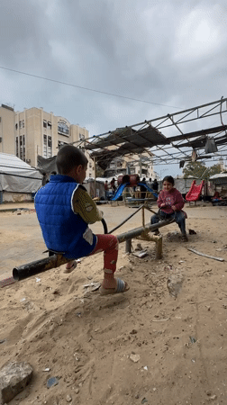 Children play on seesaw in Gaza playground