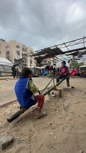 Children play on seesaw in Gaza playground