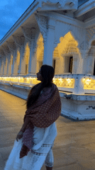 Woman photographed at illuminated Thai temple during evening visit