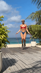 Woman exercises with jump rope at Indonesian beach resort