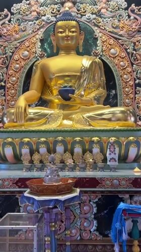 Golden Buddha statue with ornate backdrop documented in Russia