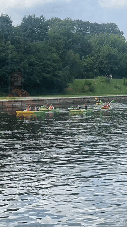 Kayaking a calm Vilnius river on a cloudy summer day