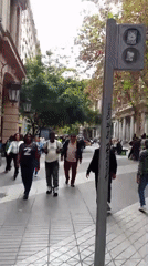 Pedestrians walk along tiled walkway in downtown Santiago