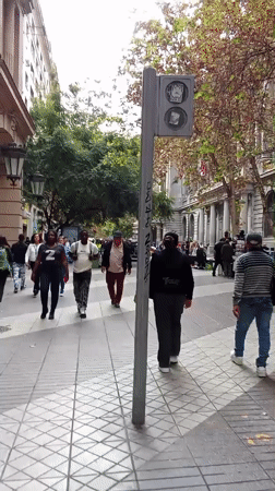 Pedestrians walk along tiled walkway in downtown Santiago