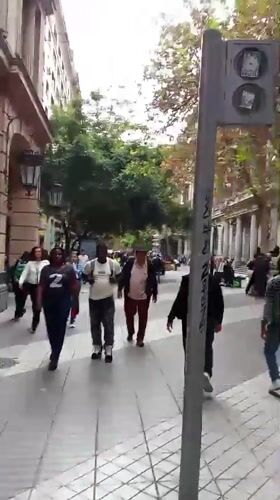 Pedestrians walk along tiled walkway in downtown Santiago