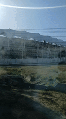 Moving vehicle captures elevated structure with white awnings in Venezuela