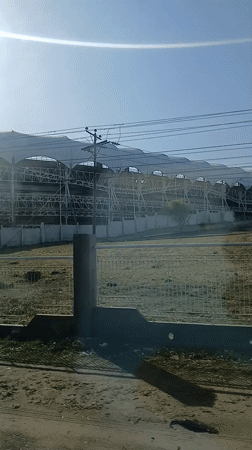Moving vehicle captures elevated structure with white awnings in Venezuela