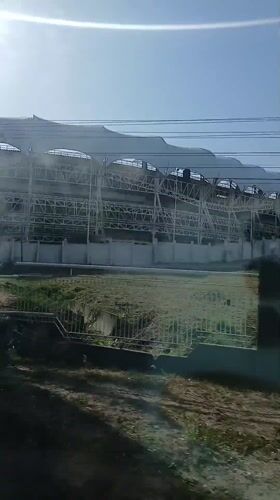 Moving vehicle captures elevated structure with white awnings in Venezuela