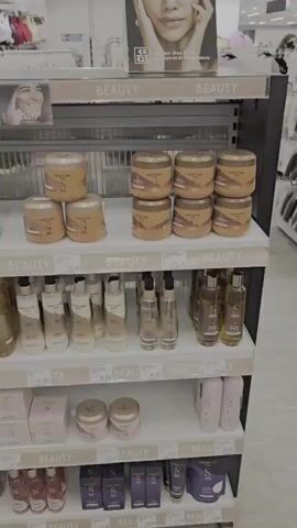 The video pans across a beauty section of a store. On the shelves are various beauty products, including jars, bottles, and boxes. A display stand with "DUNNES BEAUTY" written on it is visible. In the background, clothing racks and other store aisles can be seen.