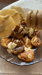 Person drizzles honey on pancakes and apples using wooden dipper