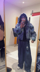 Young man films mirror selfie showcasing outfit in Noisy-le-Grand