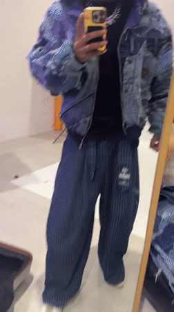 Young man films mirror selfie showcasing outfit in Noisy-le-Grand