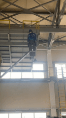 Mannequin in work gear suspended from industrial structure