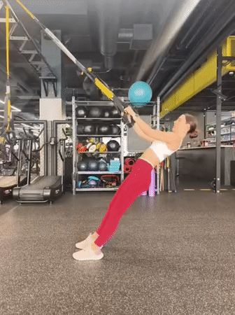 Woman performs early morning TRX workout session in Tyumen gym