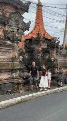 Family strolls past ornate Balinese architecture in Ubud