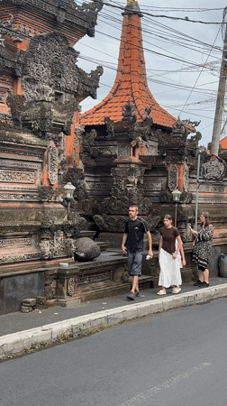Family strolls past ornate Balinese architecture in Ubud