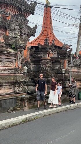 Family strolls past ornate Balinese architecture in Ubud