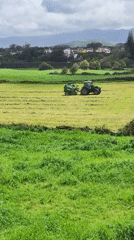 Tractor bales hay in fields near Ribeira Grande