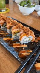 Sushi rolls with crispy topping on a wooden table in Ubud