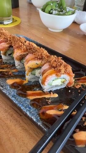 Sushi rolls with crispy topping on a wooden table in Ubud