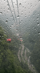 Tourists ride crowded cable cars through misty Tianmen Mountain