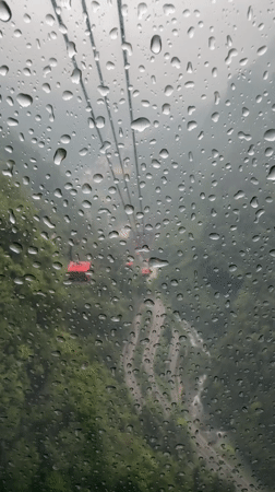 Tourists ride crowded cable cars through misty Tianmen Mountain