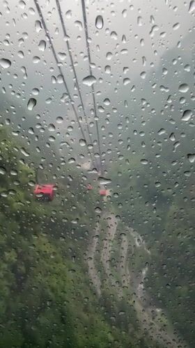 Tourists ride crowded cable cars through misty Tianmen Mountain