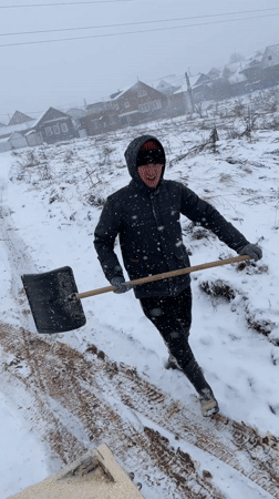 Man shovels sawdust during heavy snowfall near Sarapul, Russia