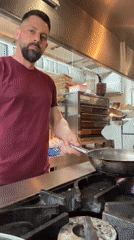 Chef performs flambé cooking technique in Leeds kitchen