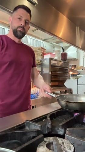 Chef performs flambé cooking technique in Leeds kitchen