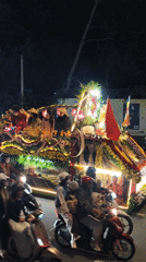 Illuminated religious procession with decorated floats travels through Da Lat