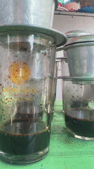Vietnamese street vendor serves traditional drip coffee in morning setup
