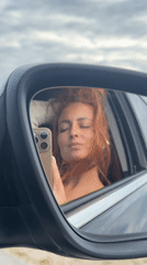 Woman takes selfie in car mirror in Russia