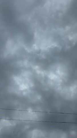 A close-up, low-angle shot shows a human hand silhouetted against a cloudy, overcast sky. The hand, held palm-outward and slightly angled, is in the foreground, obscuring a portion of the sky. The fingers are spread, with the thumb bent slightly inwards. The nails are visible and appear to be unpainted or naturally light-colored.

The sky is filled with heavy, gray clouds, suggesting a day with poor weather. There are faint horizontal lines visible in the sky behind the hand, which could be power lines or other thin, distant objects. The lighting is dim, consistent with an overcast day. The image captures a sense of gloom or perhaps a moment of defiance or reaching out.

The location is identified as Kupoyarovo, Russia. There is no visible text within the media file. The overall impression is one of a person interacting with the sky, perhaps during a moment of reflection or contemplation, under a typically cloudy Russian sky.