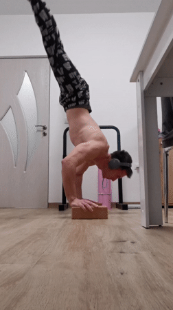 Man performs handstand on wooden block in Burgas