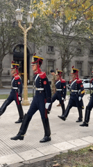 Ceremonial soldiers march in formation near pink building, Buenos Aires