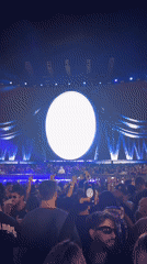 Late-night concert crowd films a fog-lit stage in New York