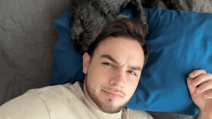 Man rests on bed with small dog in Mexico