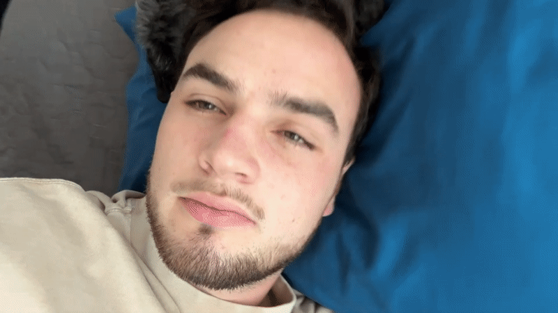 Man rests on bed with small dog in Mexico