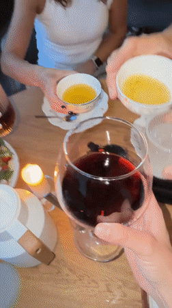 Dinner gathering with toasts and candlelit plates in Chaikovsky
