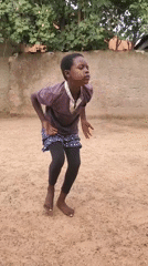 Kids dancing and playing games in an outdoor dirt area