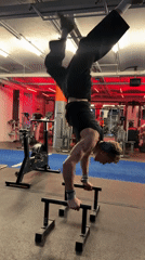 Athlete performs handstand training on parallel bars at London gym