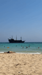 Sunny day at Nissi Beach, Ayia Napa, pirate ship offshore