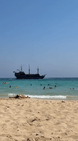 Sunny day at Nissi Beach, Ayia Napa, pirate ship offshore