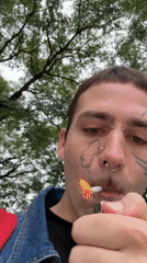 Man smokes cigarette under trees in Buenos Aires