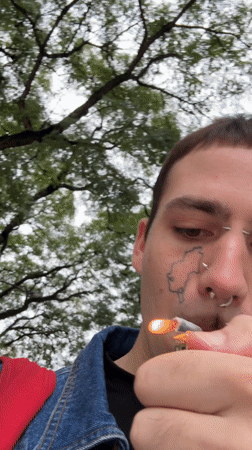 Man smokes cigarette under trees in Buenos Aires