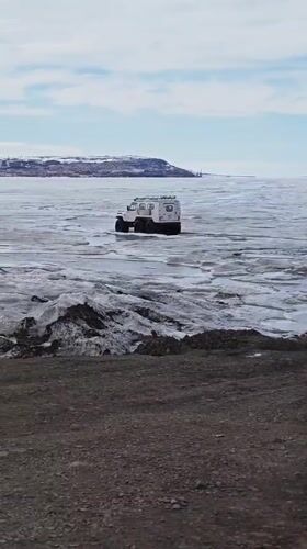 All-terrain vehicle crosses frozen waters near Russian Arctic settlement